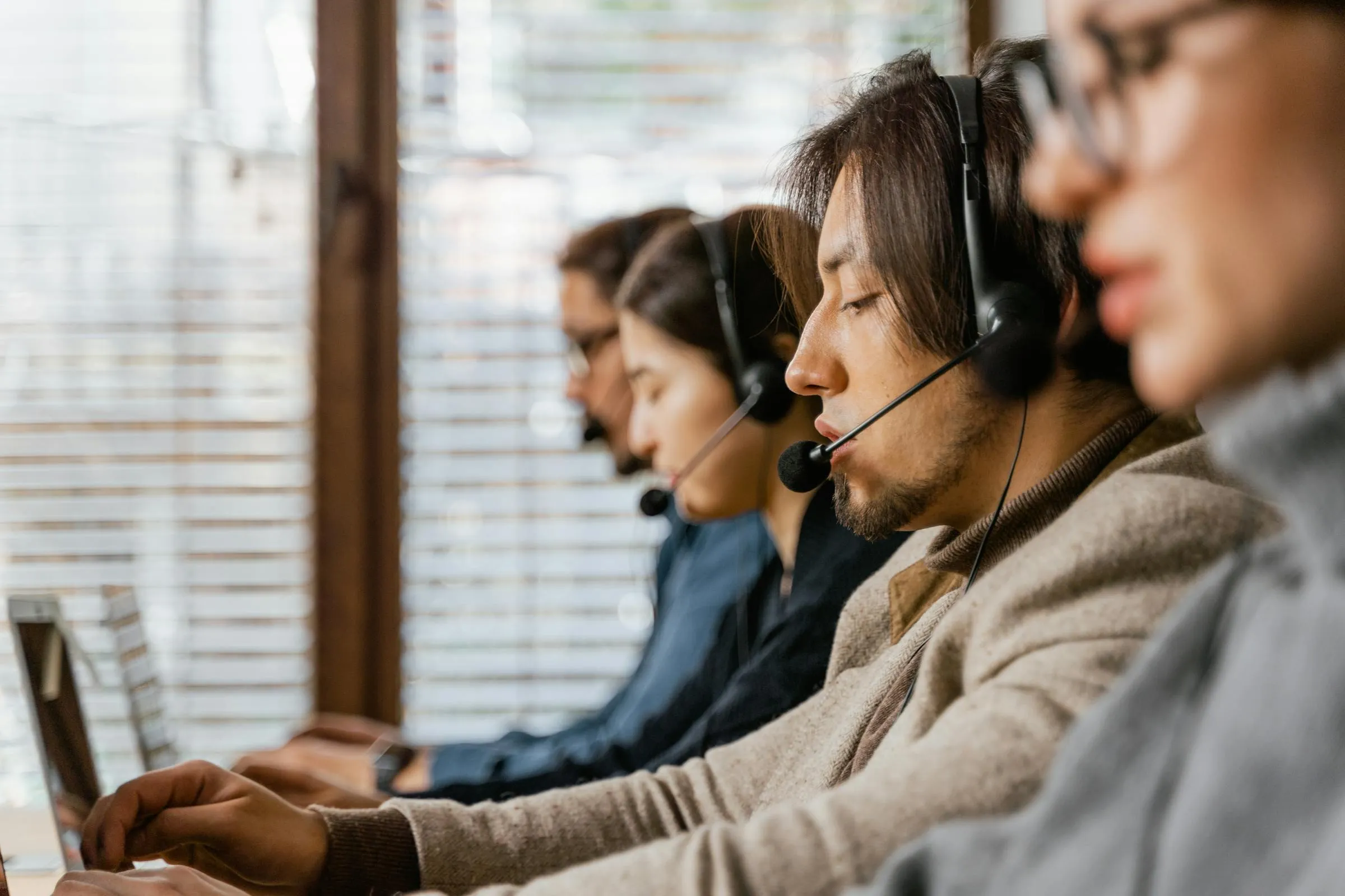 Call center agents at work, representing the agency coordination layer that autonomous AI operations are replacing.