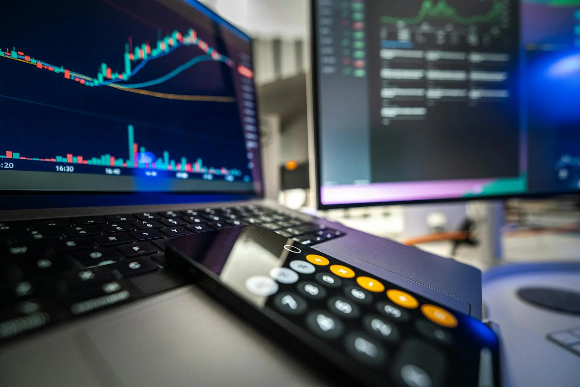 Close-up of a calculator and laptop screen showing financial analysis on a desk, representing the gross-to-net cost-stack arithmetic for a Dubai holiday home investment