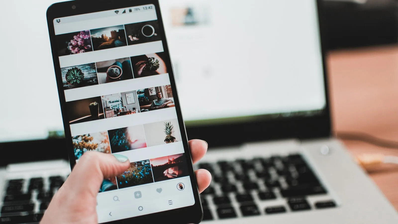 Smartphone displaying a photo grid in front of a laptop, representing the process of creating and marketing Dubai holiday home listings across platforms